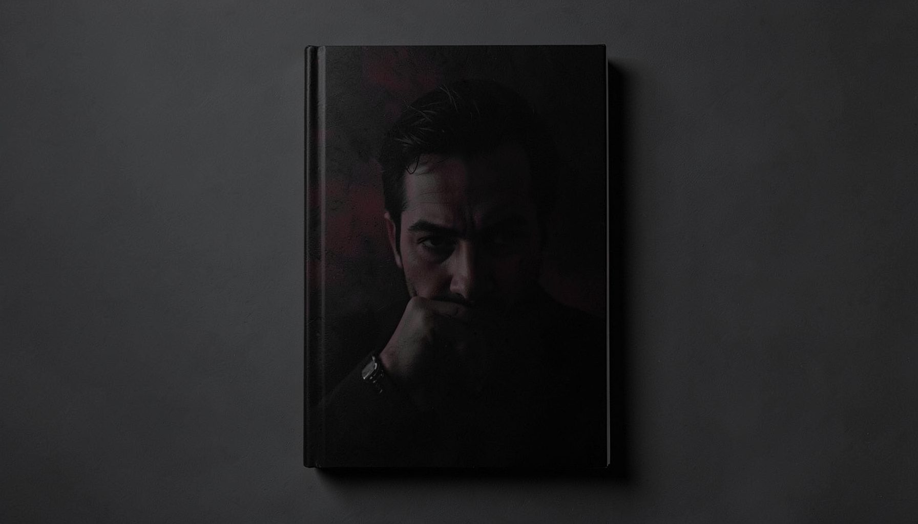 A tense, shadow-filled book cover with deep charcoal and crimson accents
